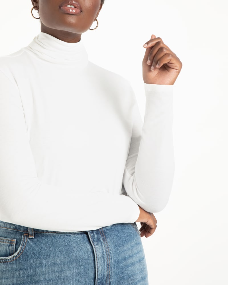 Front of a model wearing a size 14/16 Dionne Layering Turtleneck in Soft White by ELOQUII. | dia_product_style_image_id:236268